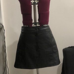 Snap front “leather” mini skirt